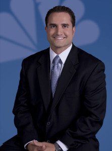 A man in a suit and tie is smiling for the camera