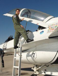 A man is standing on a ladder next to a fighter jet with the number 7 on it