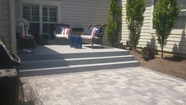 A patio with chairs and a table in front of a house.