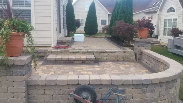 A wheelbarrow is parked in front of a brick walkway leading to a house.