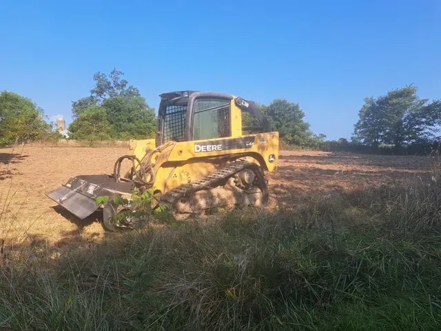 A yellow bulldozer is sitting in the middle of a field.