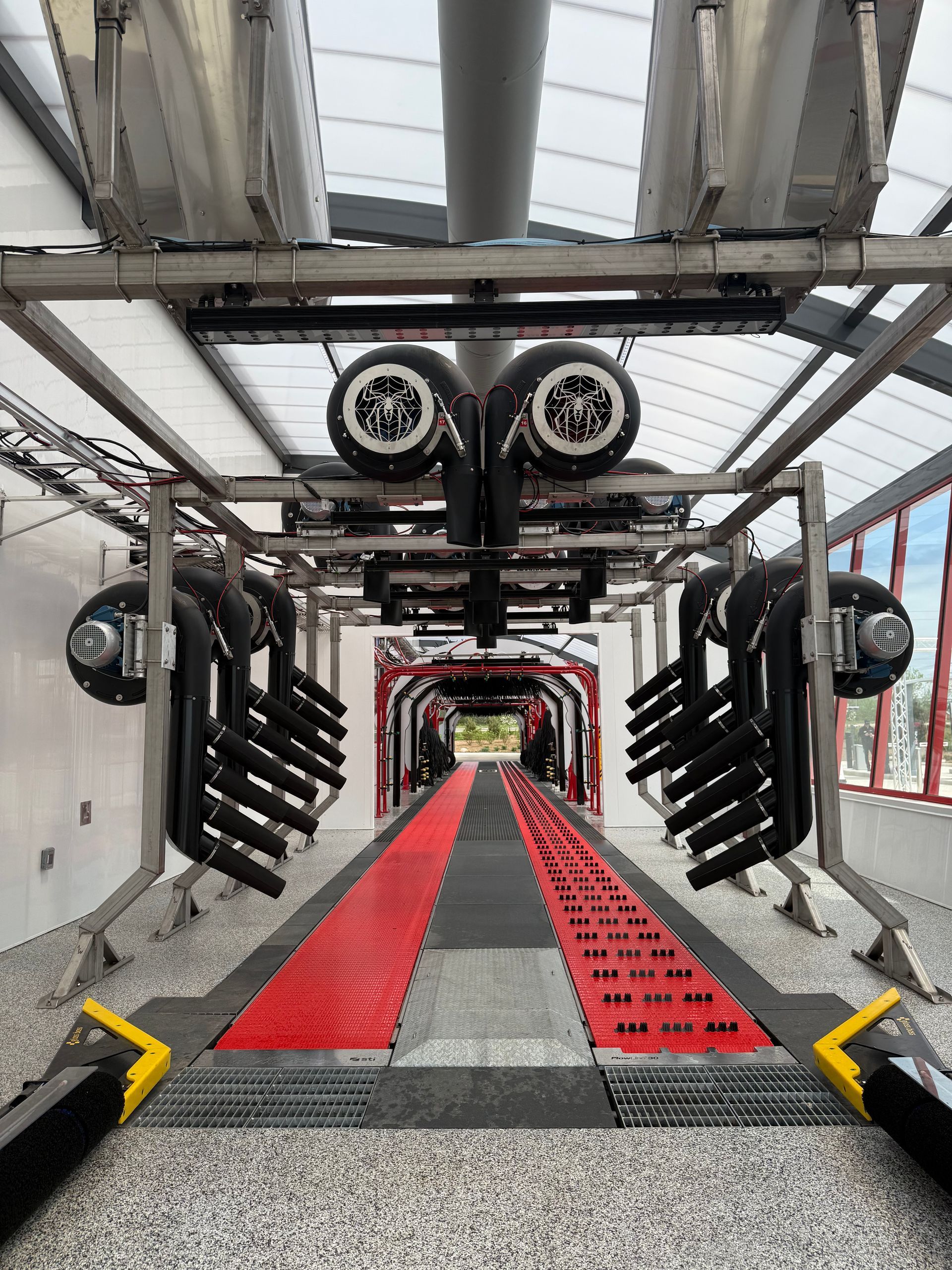 The inside of a car wash with a red and black mat.