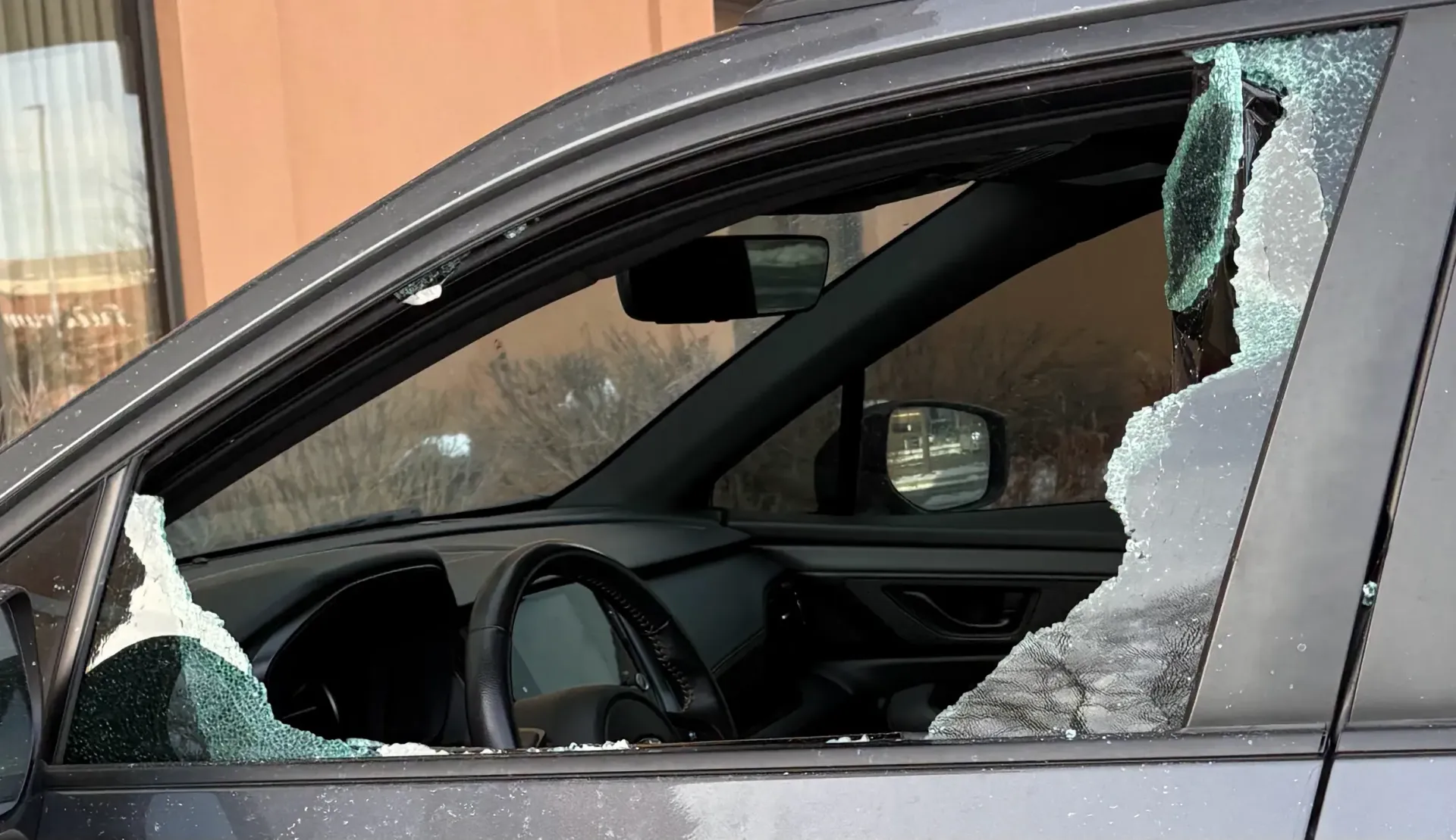 Technician setting replacement windshield into vehicle frame