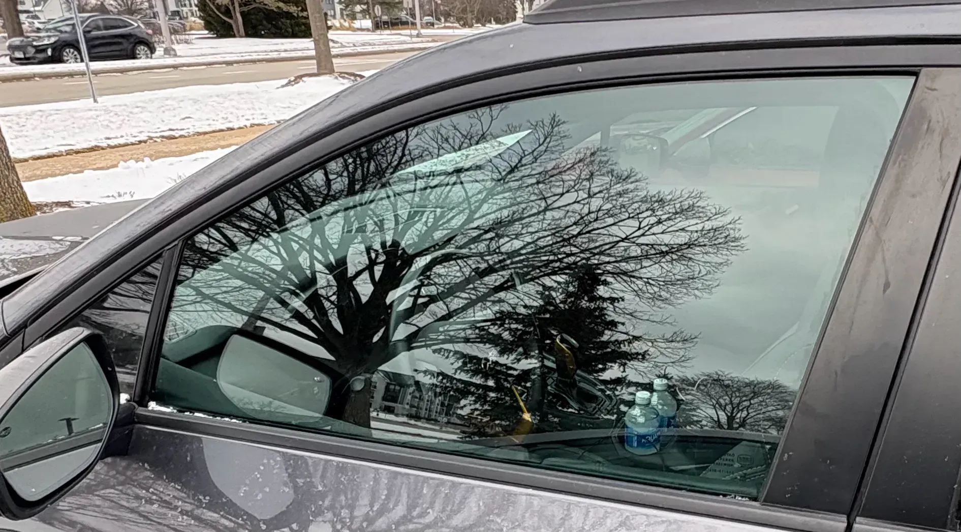 Close-up of gloved hands on auto glass trim and seals