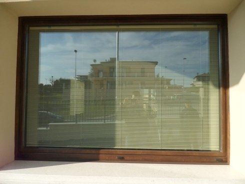 Finestra con cornice marrone e persiane orizzontali chiuse