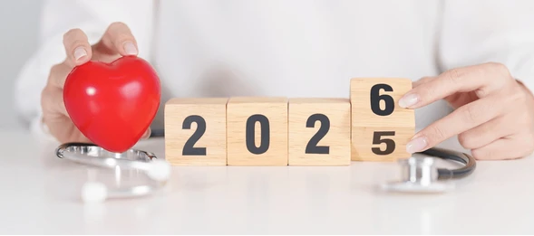 Person holding a red heart and wooden blocks spelling 