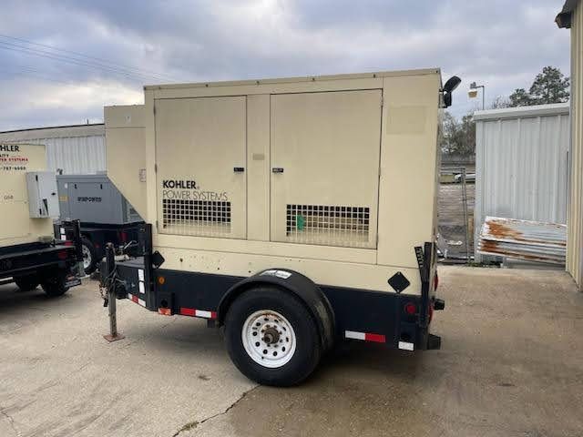 A kohler generator is on a trailer in a parking lot