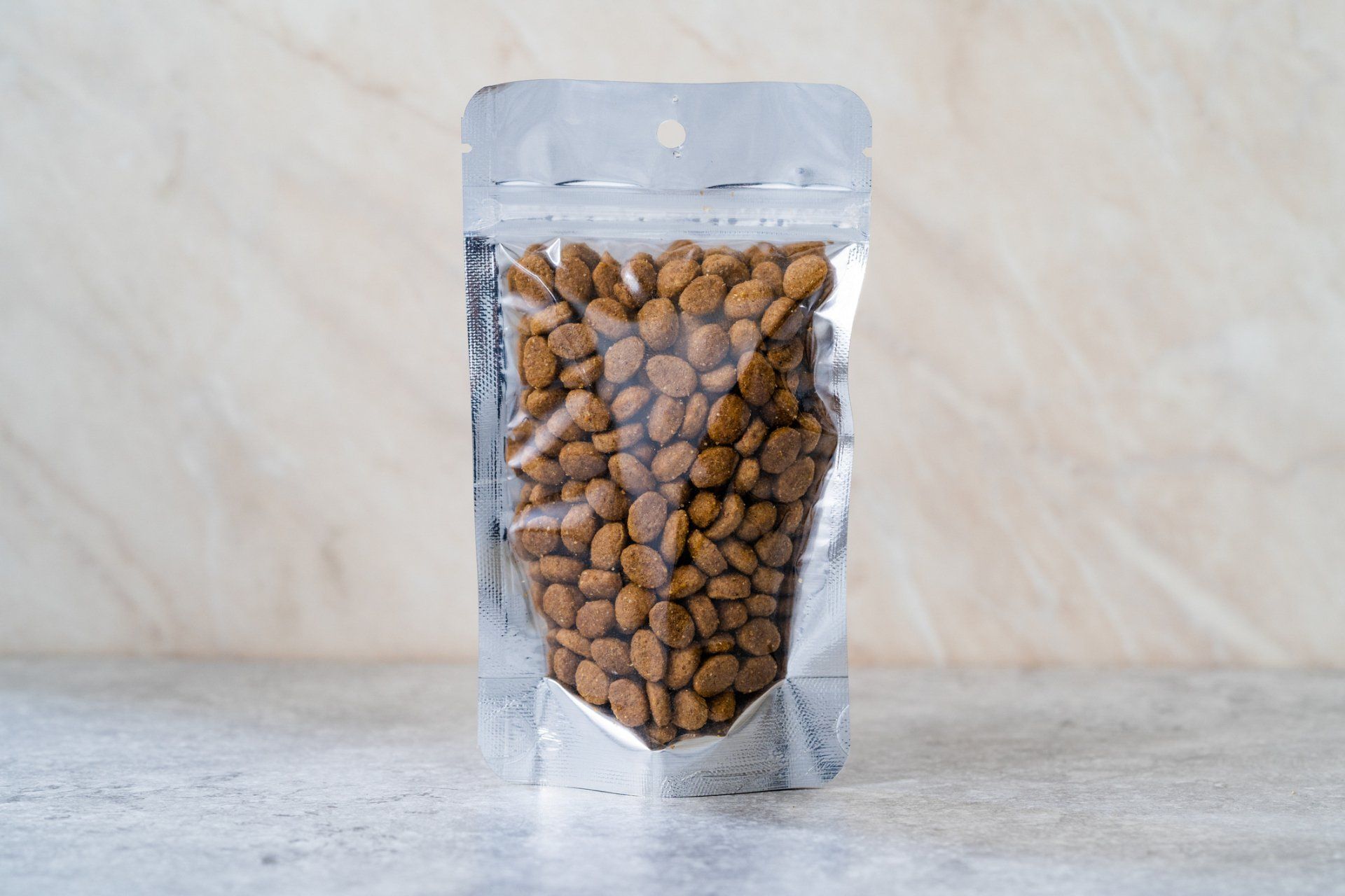 Dog Food — Madison, WI — Noah's Ark Pet Center Clear bag filled with brown pet food, sealed with a silver top, on a white surface.