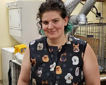 Kelly — Madison, WI — Noah's Ark Pet Center Woman in dog-print top smiles, standing near a laundry machine and pet crate in a utility room.