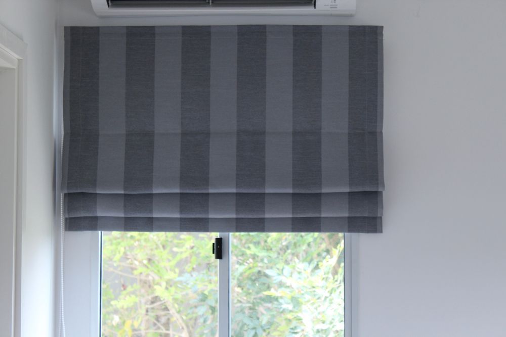 Grey Striped Roman Shade Over a Window With Daylight and Greenery Outside — Another Blind Man in Buderim, QLD