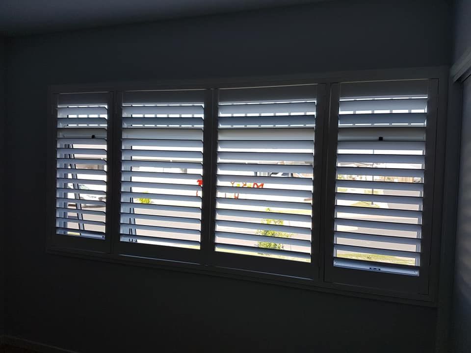 Closed White Window Shutters With Daylight Filtering Through, in a Dim Room — Another Blind Man in Tewantin, QLD