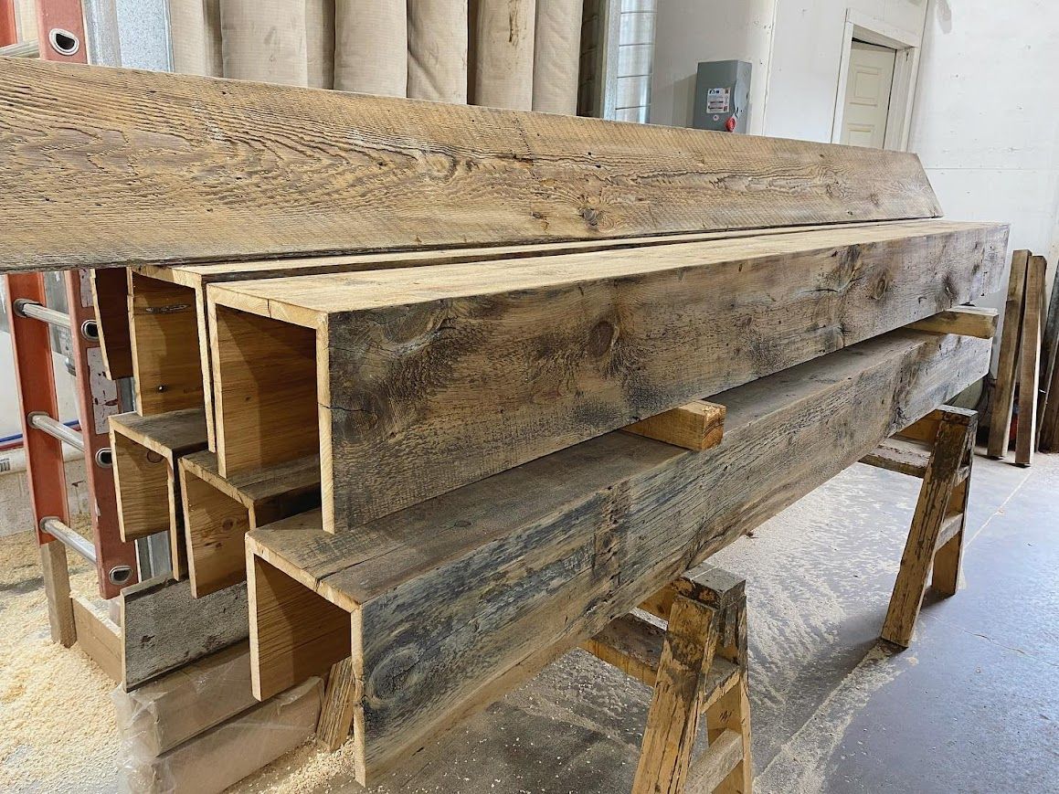 Reclaimed wood beams on sawhorses in a workshop for acclimation.