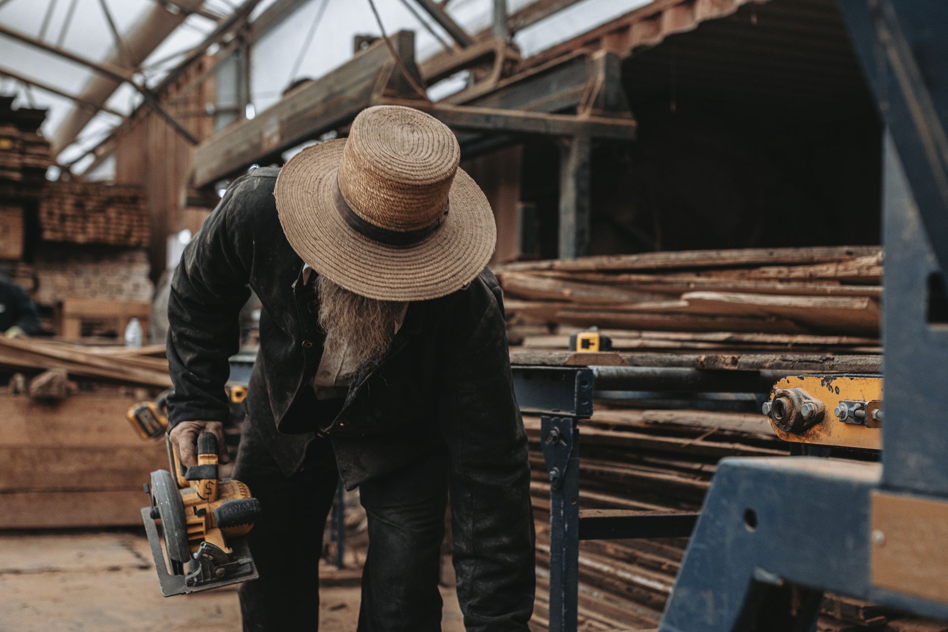 A man is working on a piece of wood in a woodworking shop.