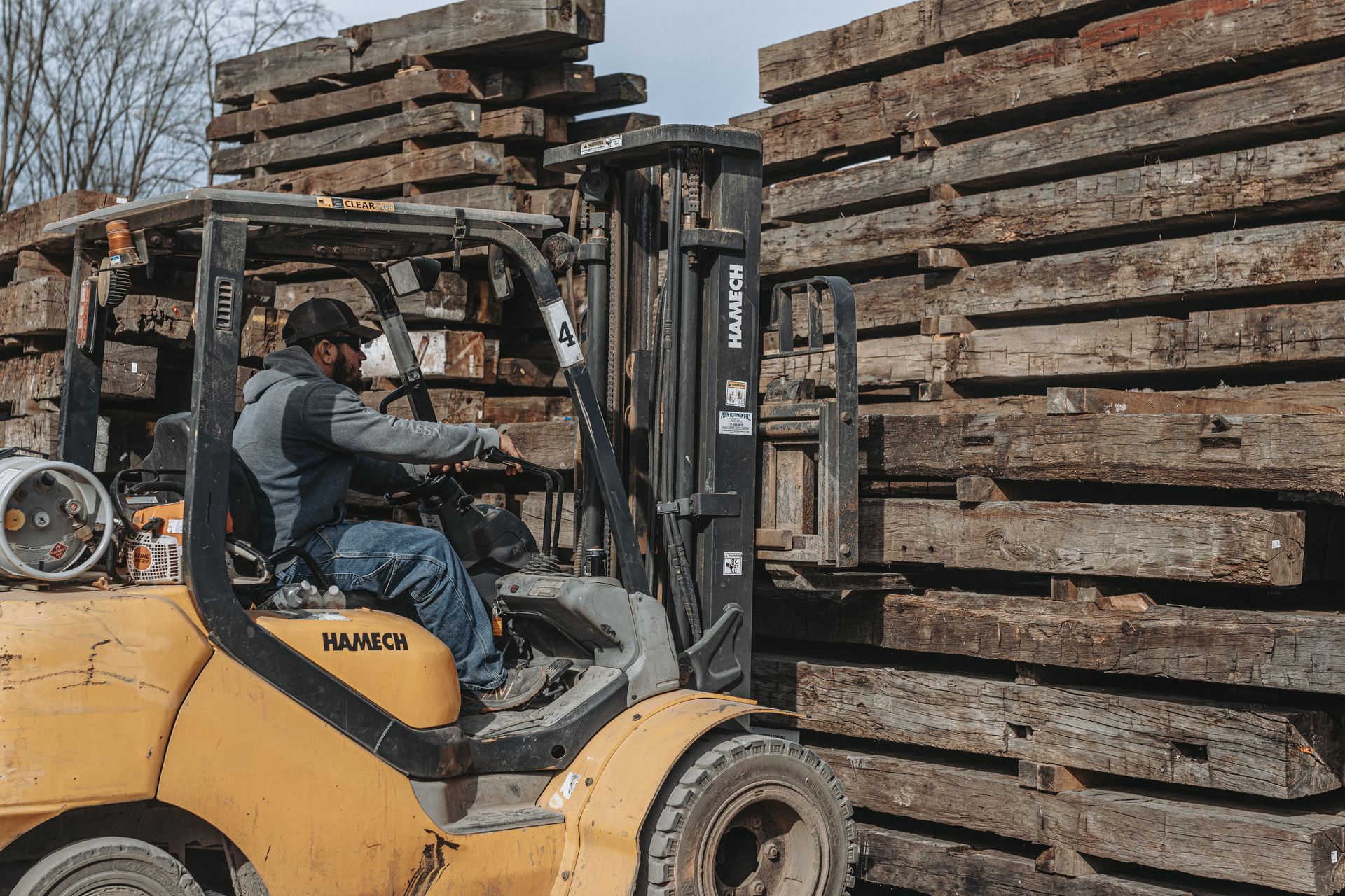 Forklift moving stacked beams, showcasing what timber is used for in industrial settings.