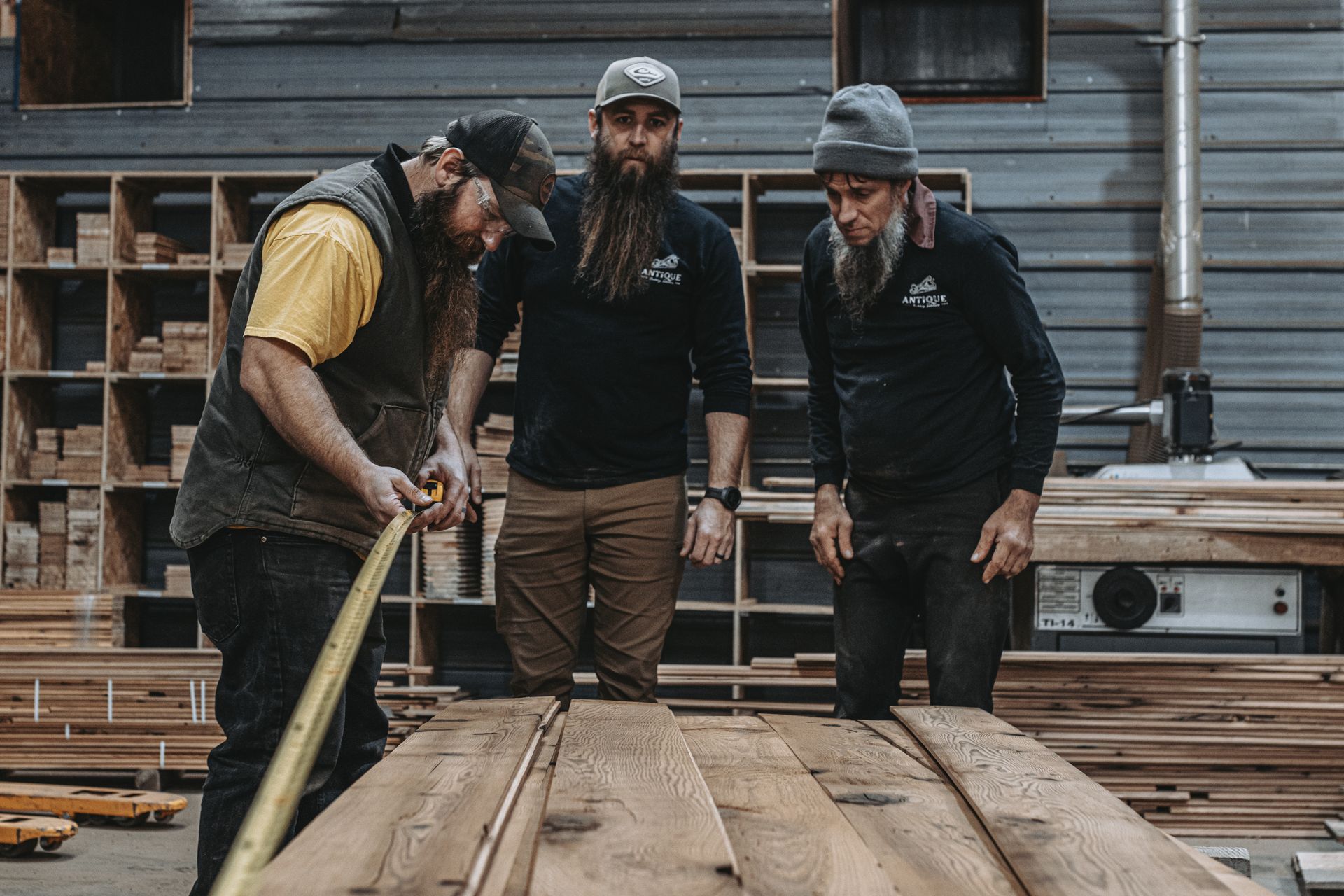 Workers measuring wooden planks using the board foot formula.