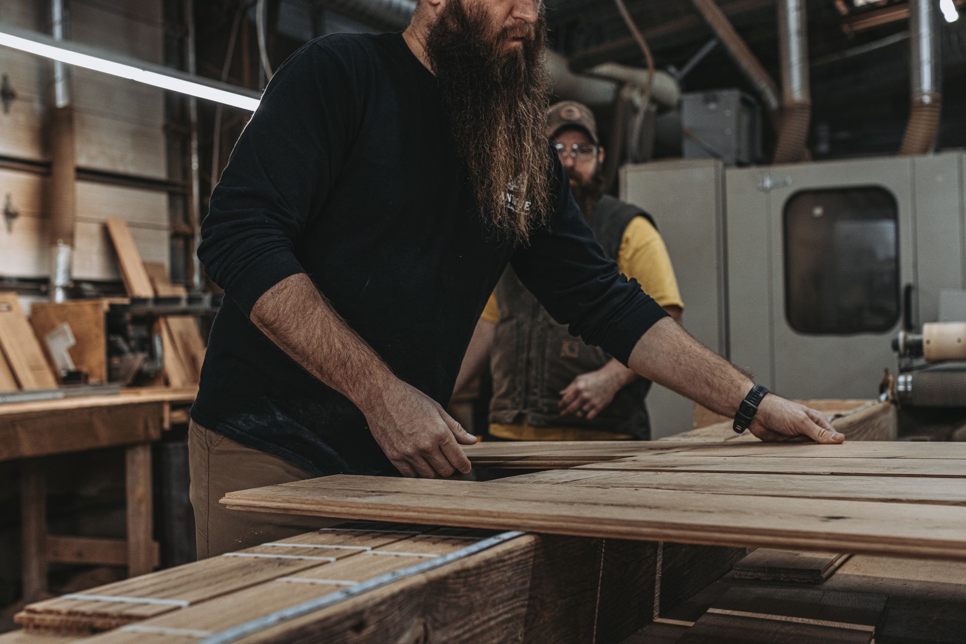 Craftsman inspecting wooden planks for custom design elements.