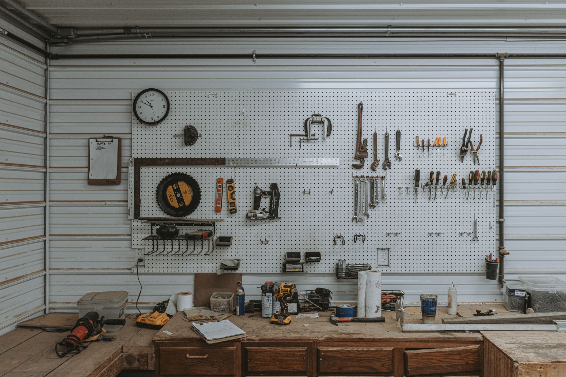 Timber frame tools organized on a workshop pegboard wall.