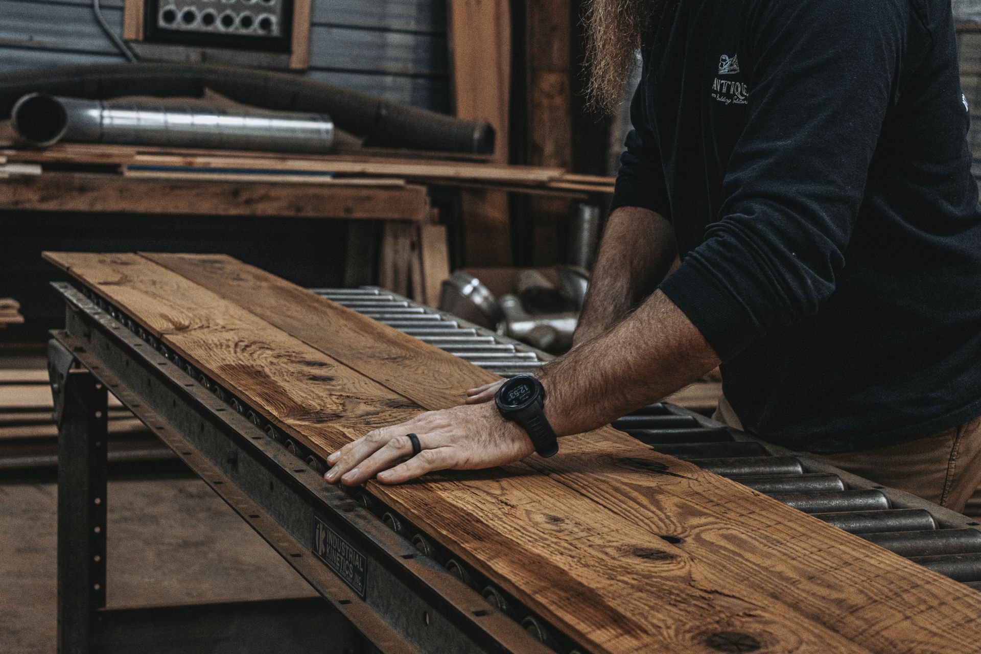Worker inspecting wooden planks with visible annular rings.