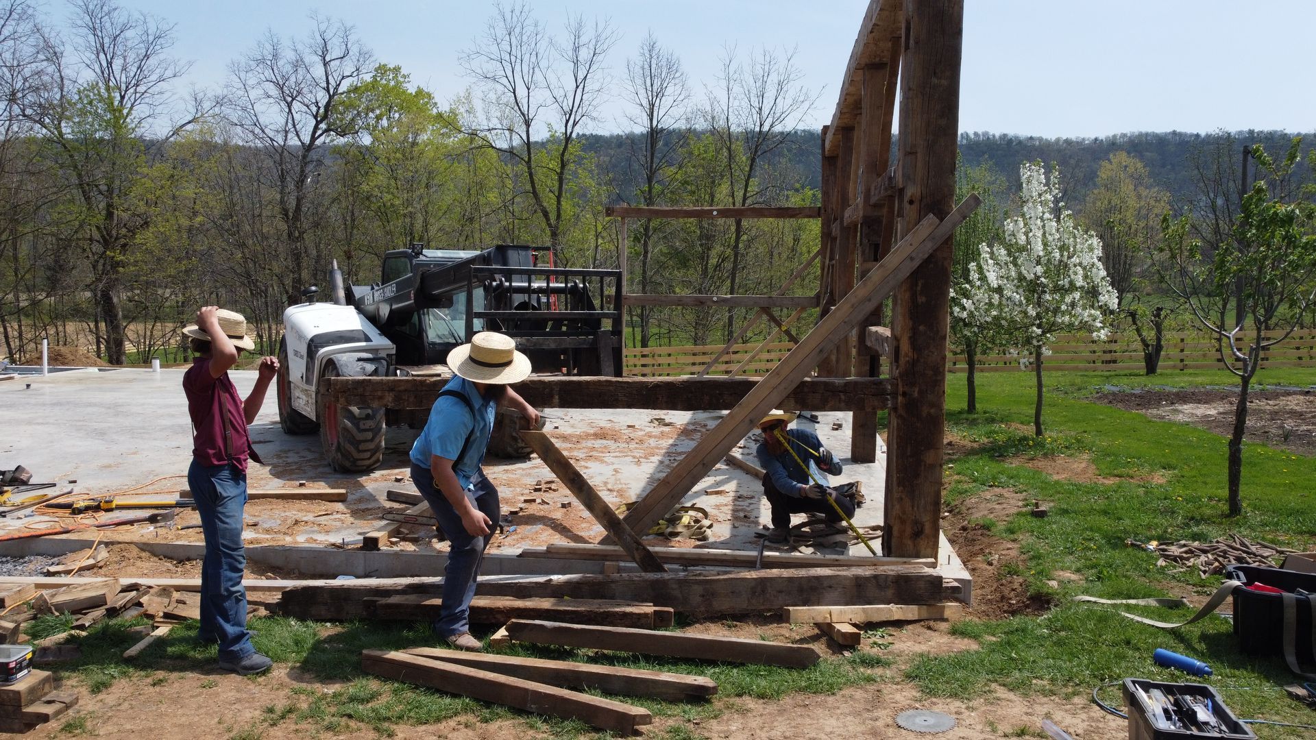 Workers assembling a timber frame structure using traditional architectural timber joinery.