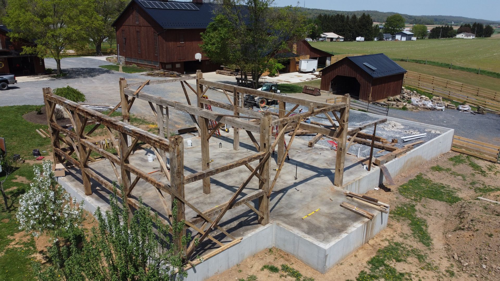 Timber frame structure under construction, an early stage in the process to build a barndominium on a rural property.