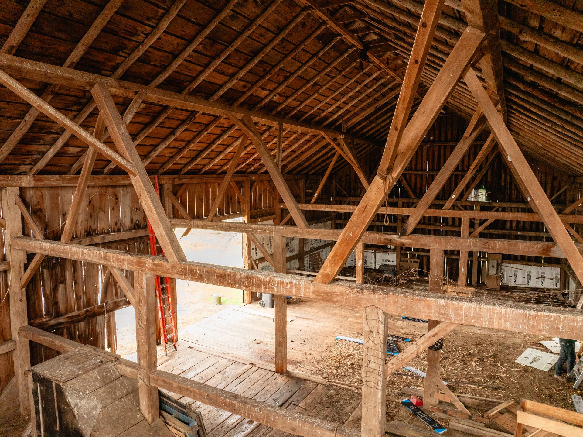 Interior of a historic reclaimed timber barn featuring exposed gunstock posts