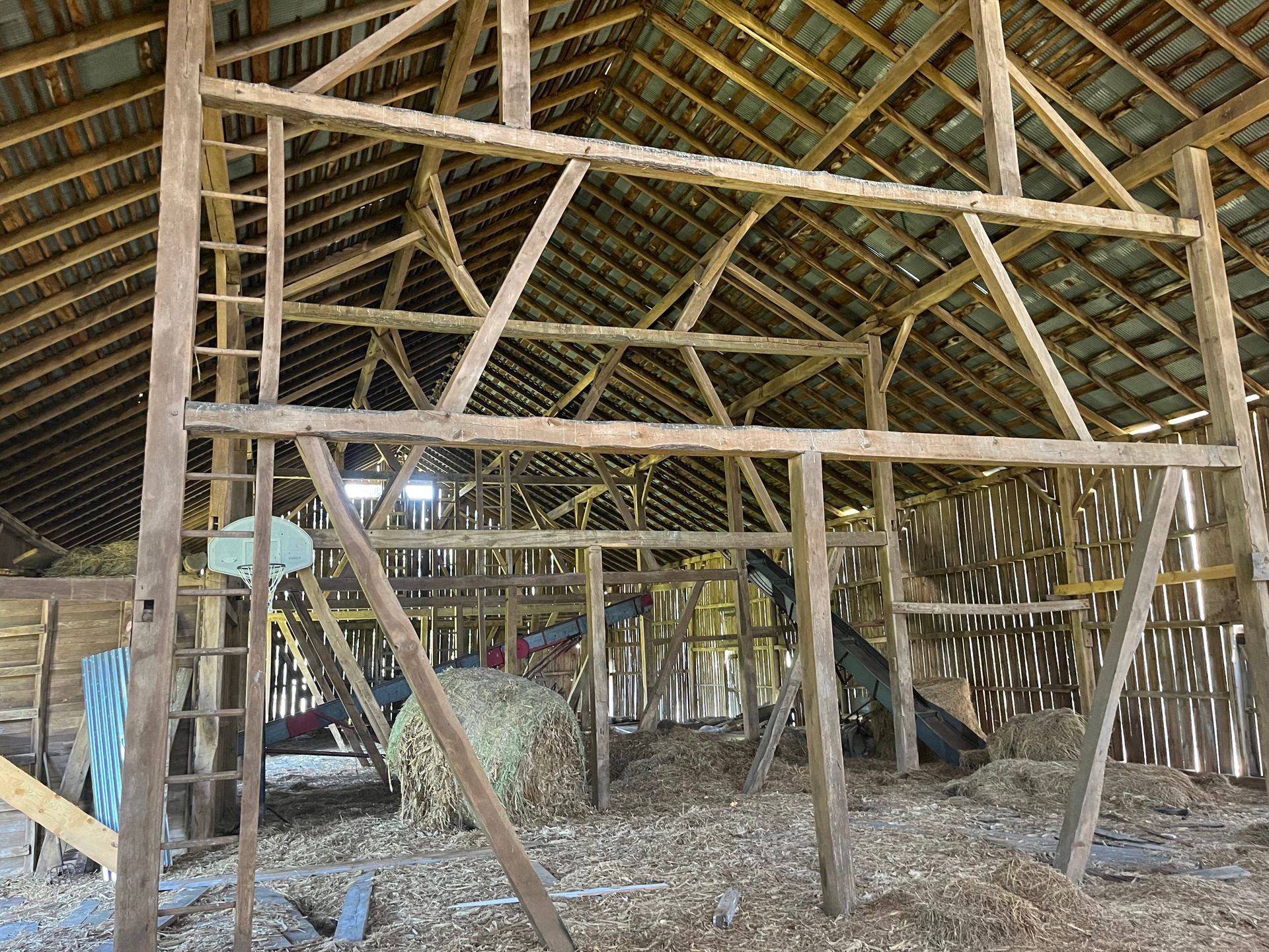 Interior of a historic Pennsylvania timber barn with exposed gunstock posts and wooden rafters.