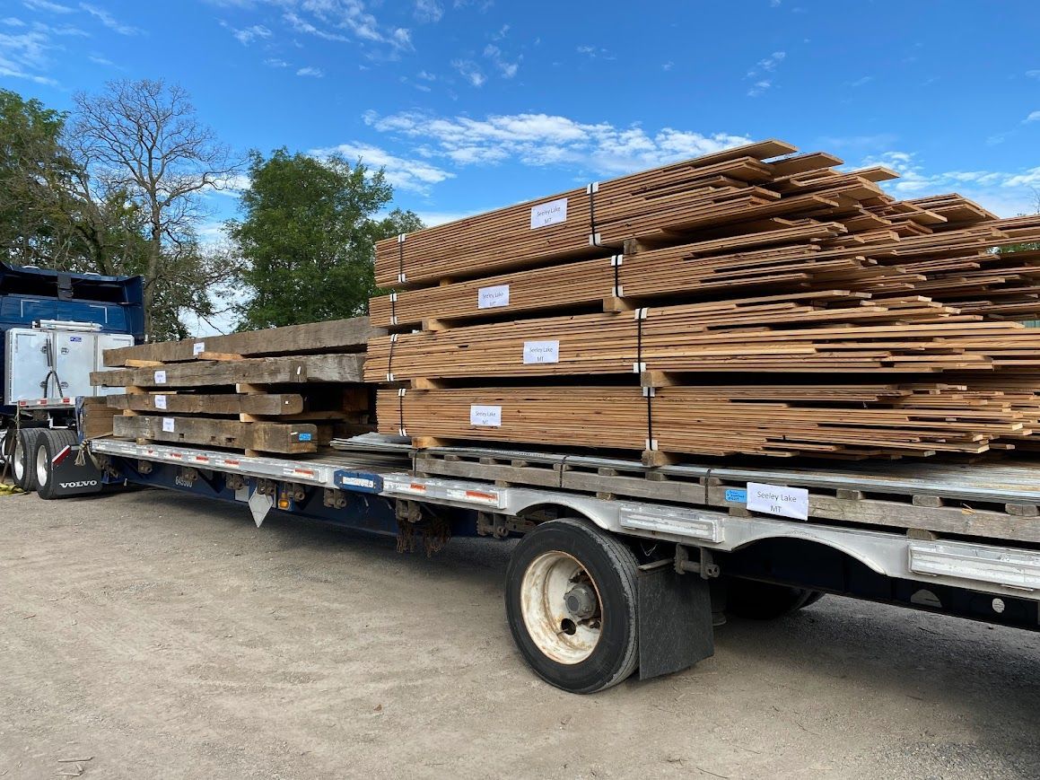 Flatbed truck loaded with old barn wood for sale.