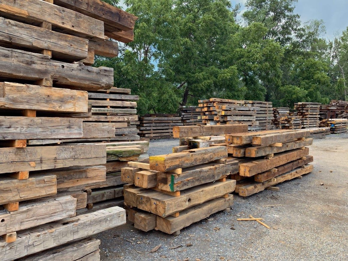 Stacks of wooden beams during historic barn dry-in phase.