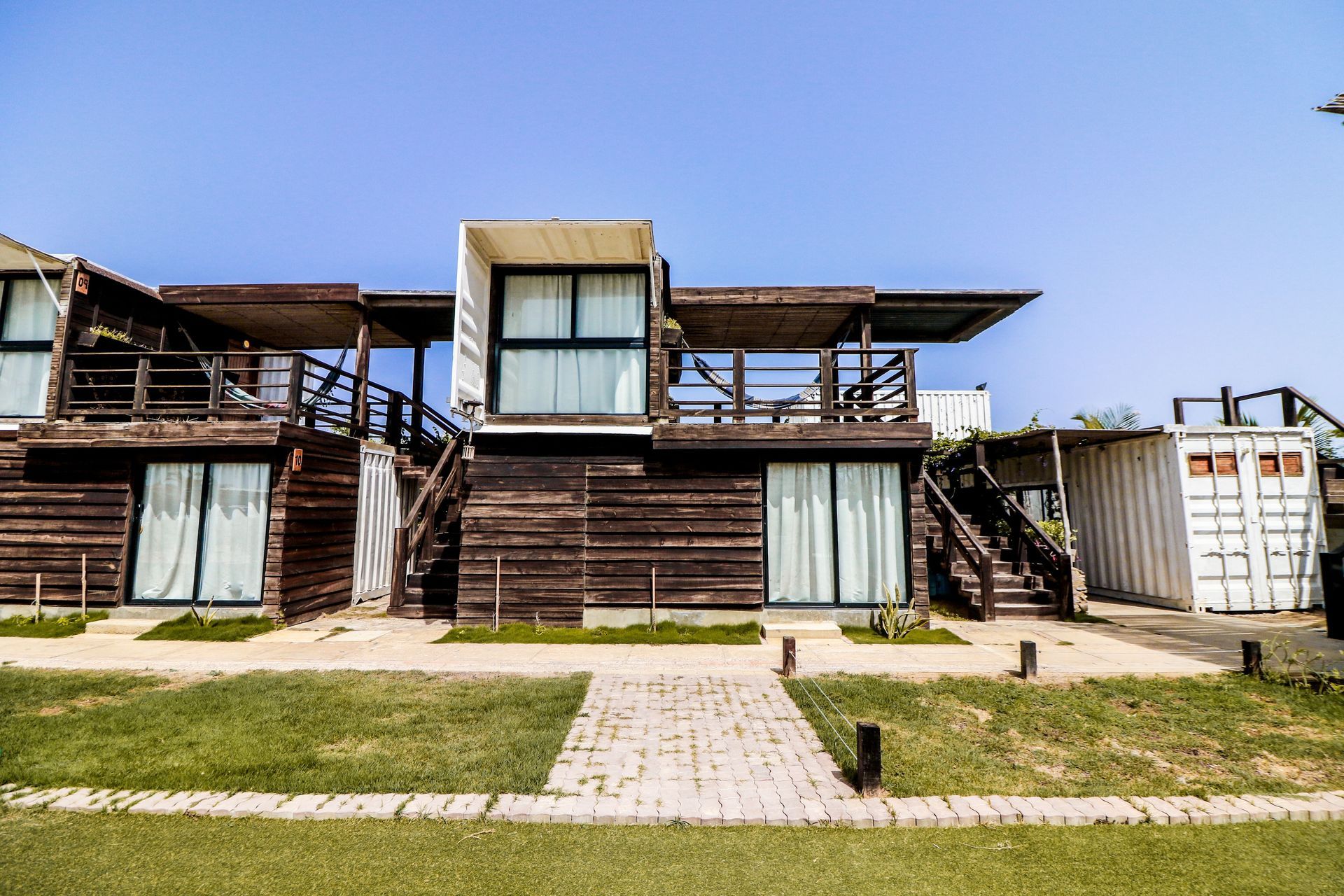 Pennsylvania container homes with dark timber cladding, glass doors, and covered balconies.