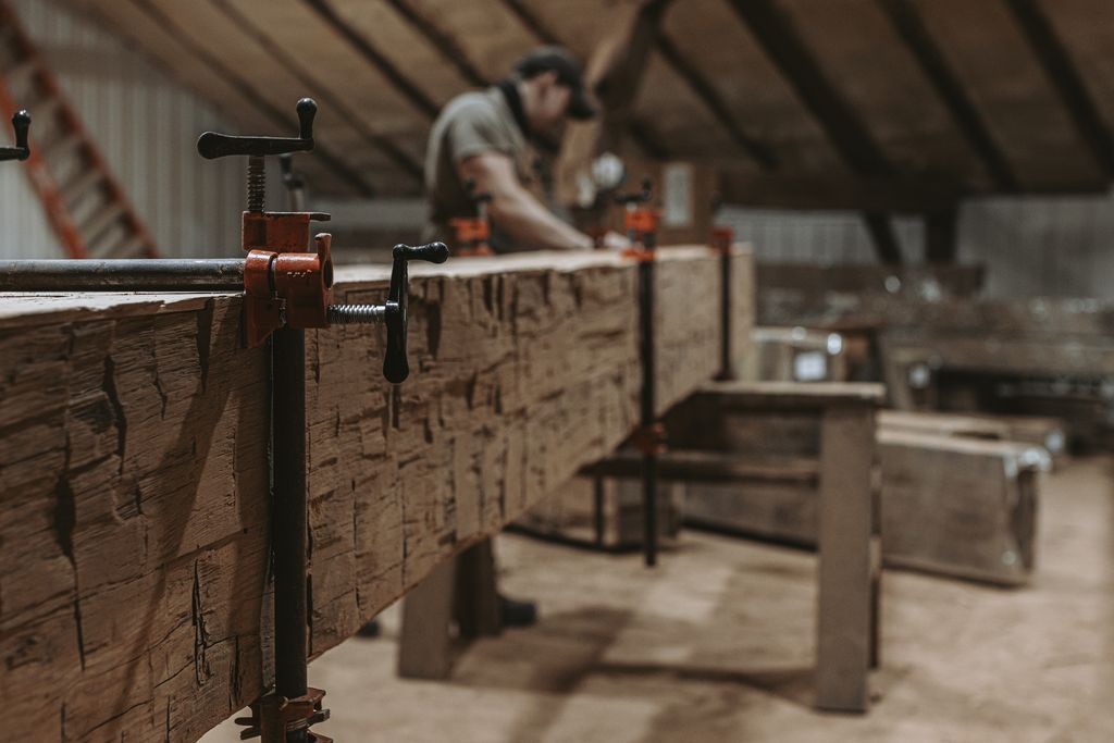 Wooden beam secured with clamps, highlighting wood joinery techniques.