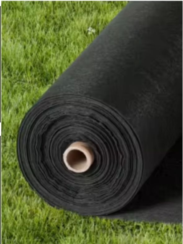 Rolled black landscape fabric with a cardboard core on green grass