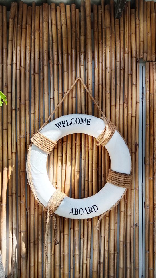 Wooden beach sign with “WELCOME,” “beach,” and “Salt, sand & sea” on a rope hanger.