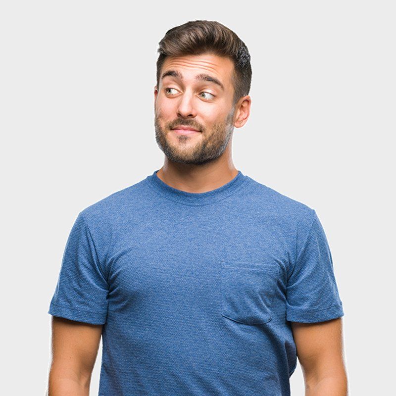 Man in a blue T-shirt looking off to the side against a white background
