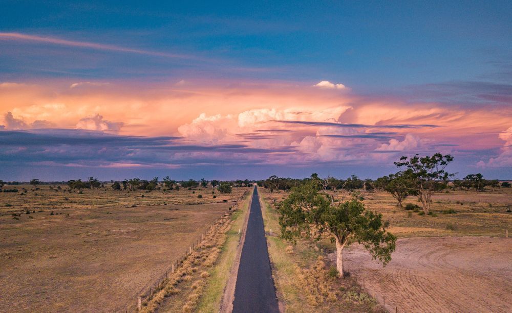 Aerial View Of A Road Going Through A Desert Landscape At Sunset — Comfort N Care Support QLD Pty Ltd In Goondiwindi, QLD