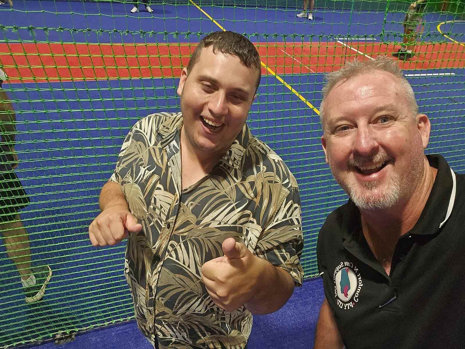 Two Men Are Standing Next to Each Other And Taking Selfie on A Tennis Court — Comfort N Care Support QLD Pty Ltd In Toowoomba City, QLD