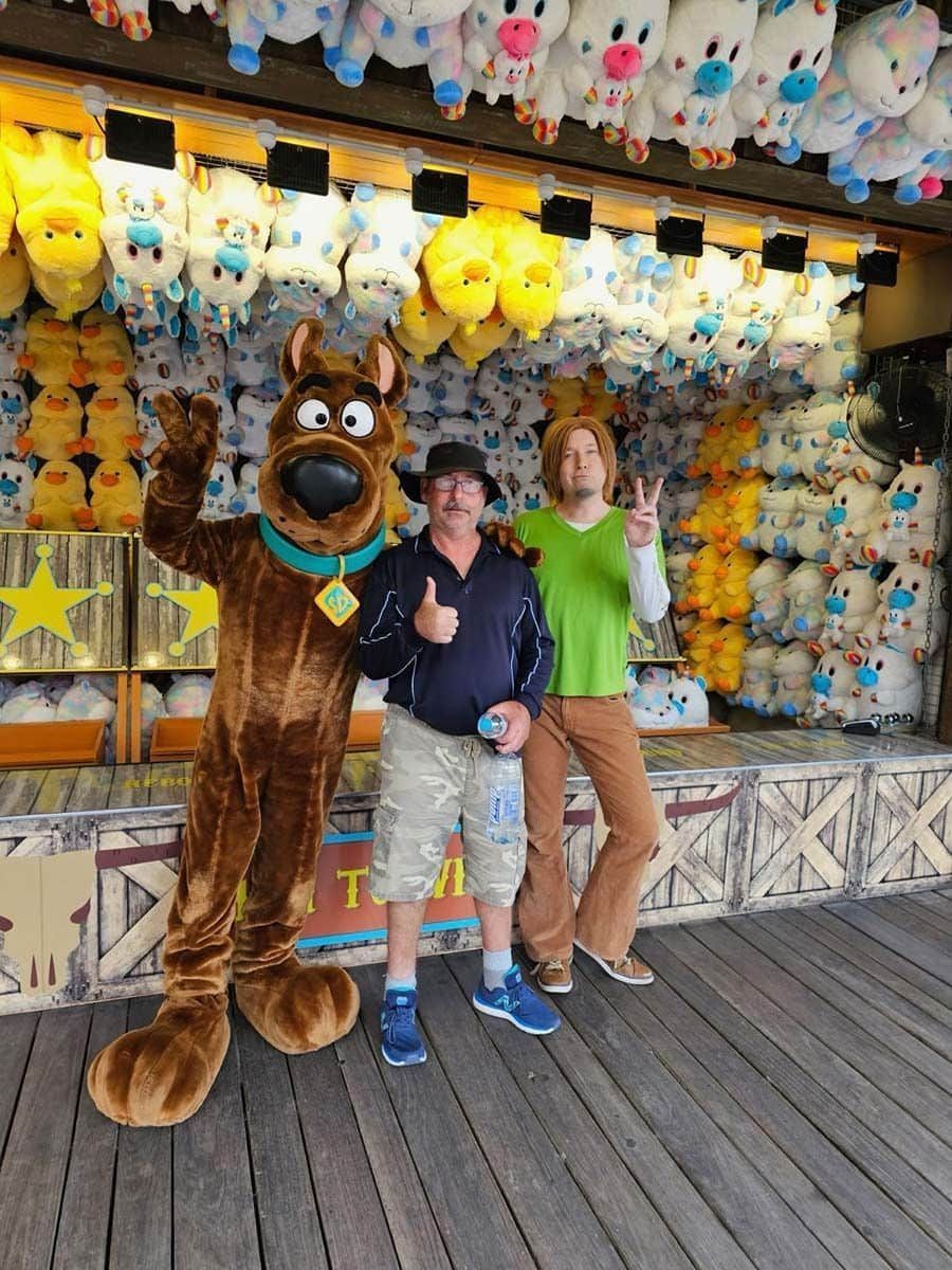 Scooby Doo and Shaggy Are Posing for A Picture in Front of A Wall of Stuffed Animals — Comfort N Care Support QLD Pty Ltd In Toowoomba City, QLD