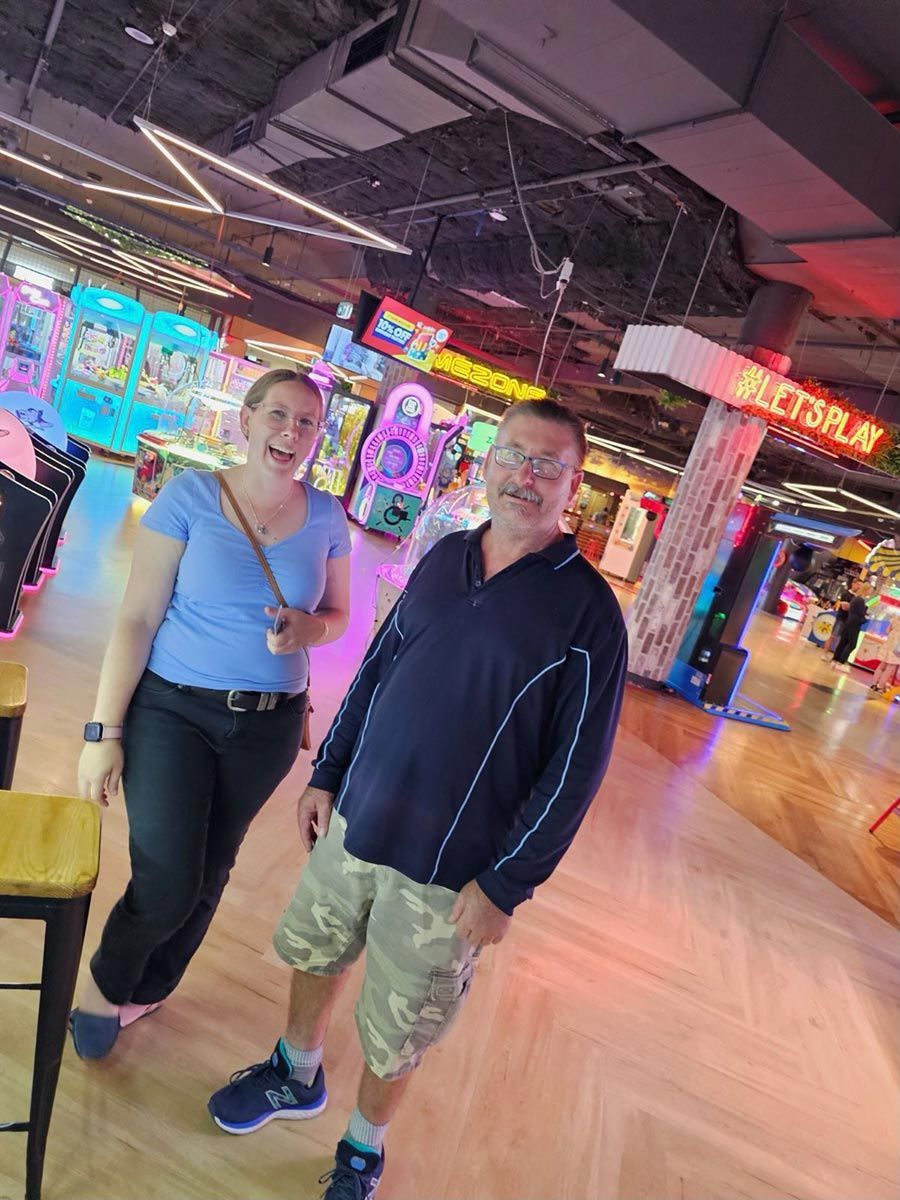 A Man and A Woman Are Standing Next to Each Other in An Arcade — Comfort N Care Support QLD Pty Ltd In Toowoomba City, QLD