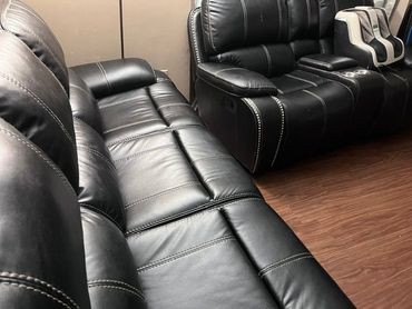 Two cleaners vacuuming a living room with a sofa, curtains, and TV unit