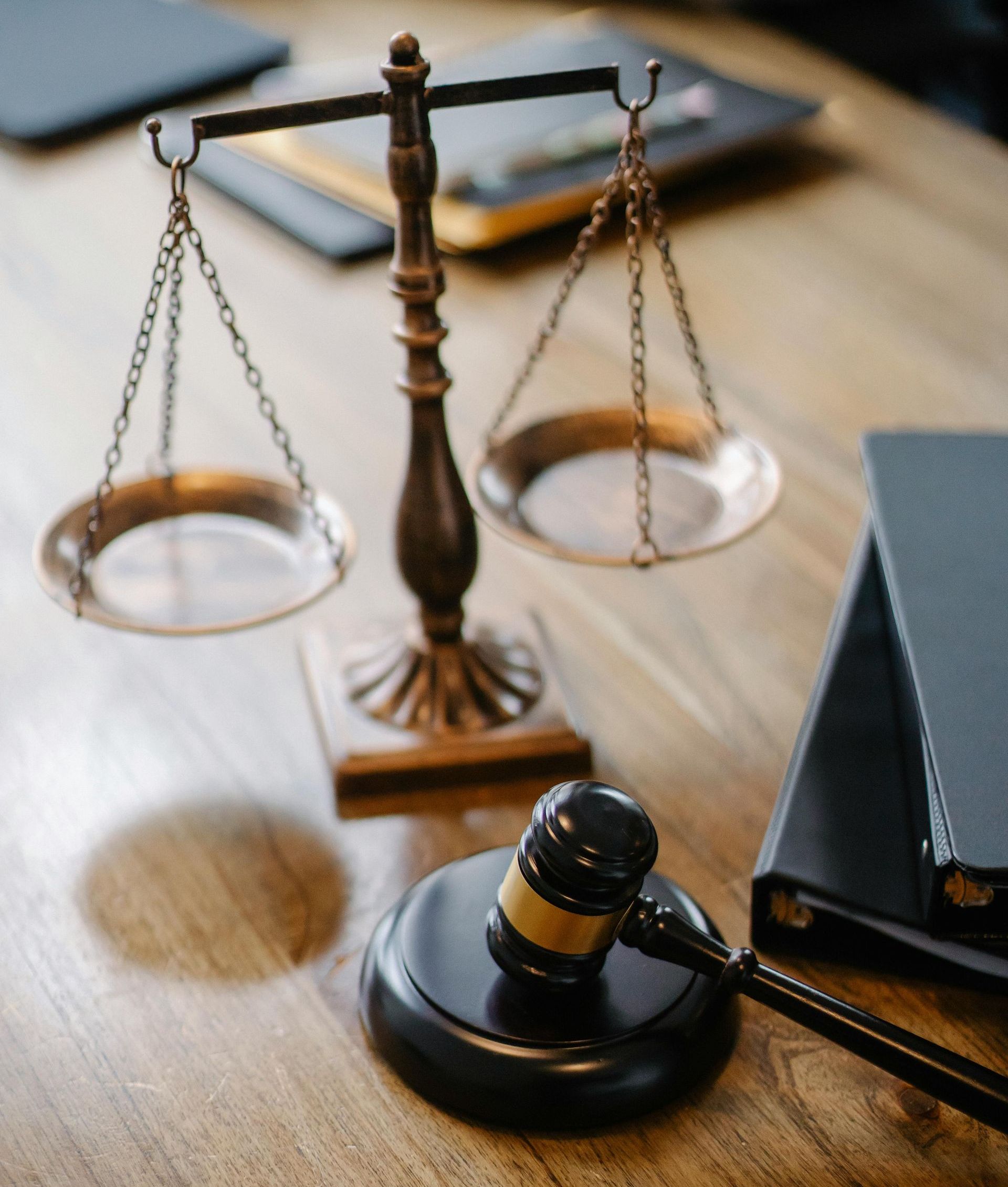 Judge's scales and gavel on a desk with legal files in the background