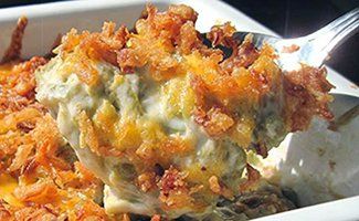 Forkful of cheesy baked casserole topped with crispy orange-brown crumbs on a white plate