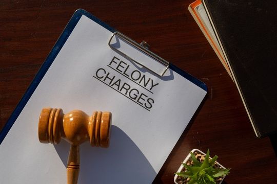 A wooden gavel lies on a clipboard with the text