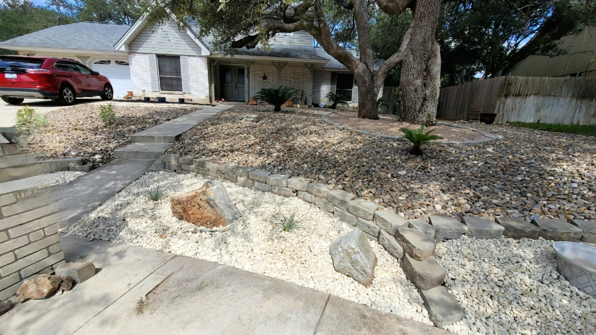 A patio with a fireplace and a tree in the background .