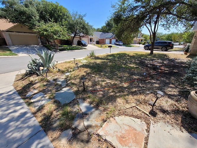 A stone walkway leading to a house in a residential neighborhood .