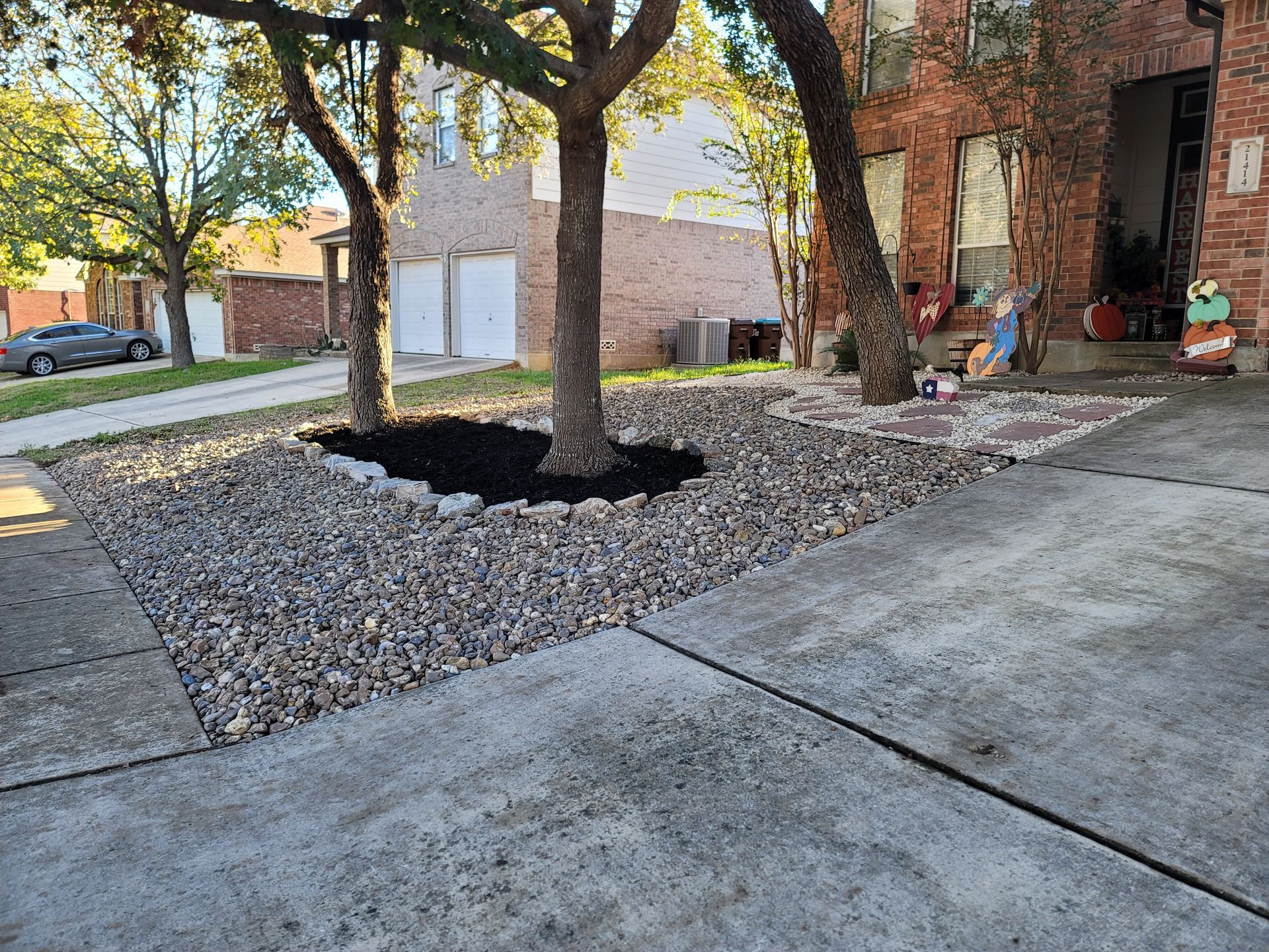 A truck is parked on the side of the road next to a stone walkway .