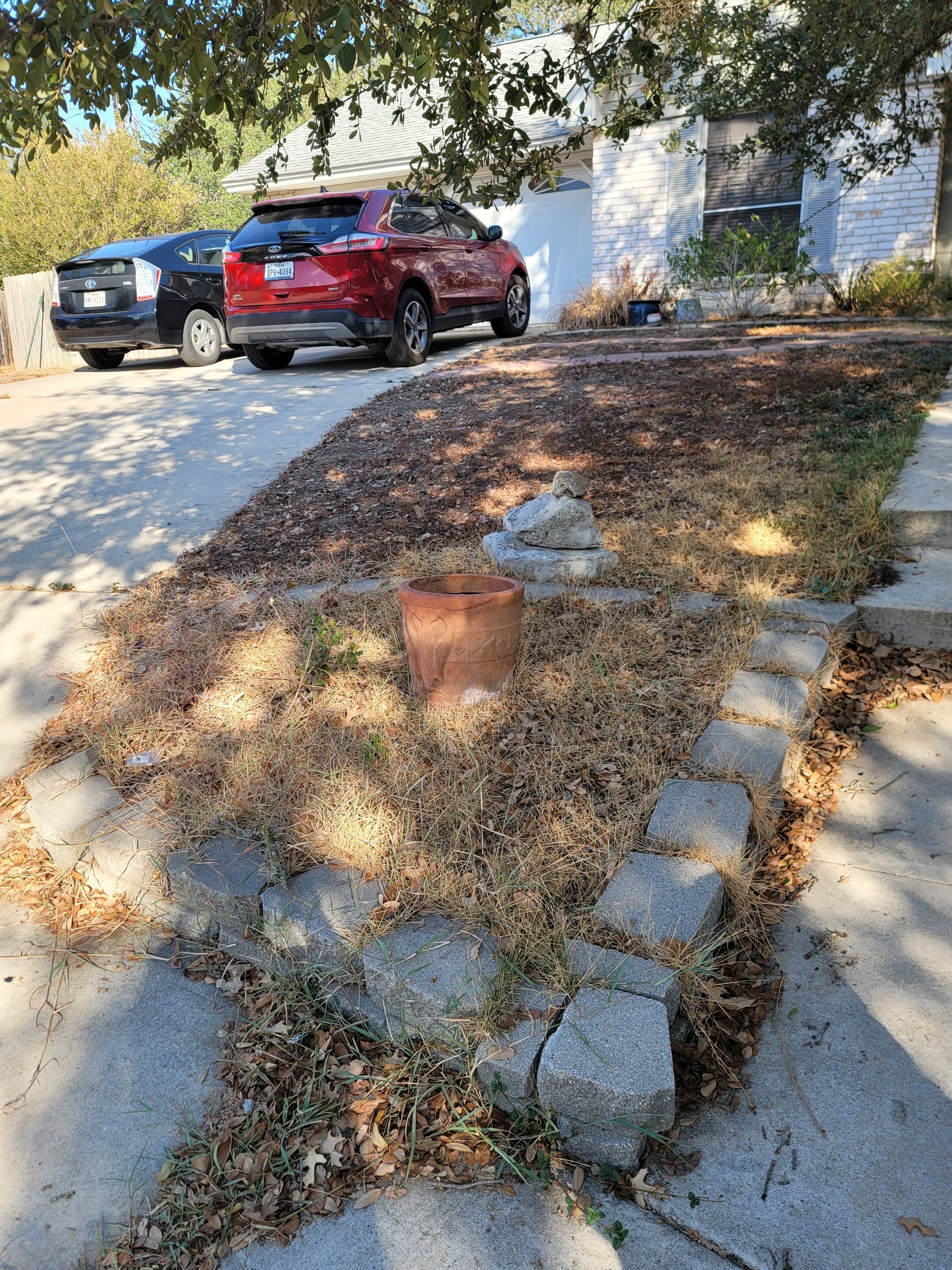 A red car is parked in the driveway of a house .