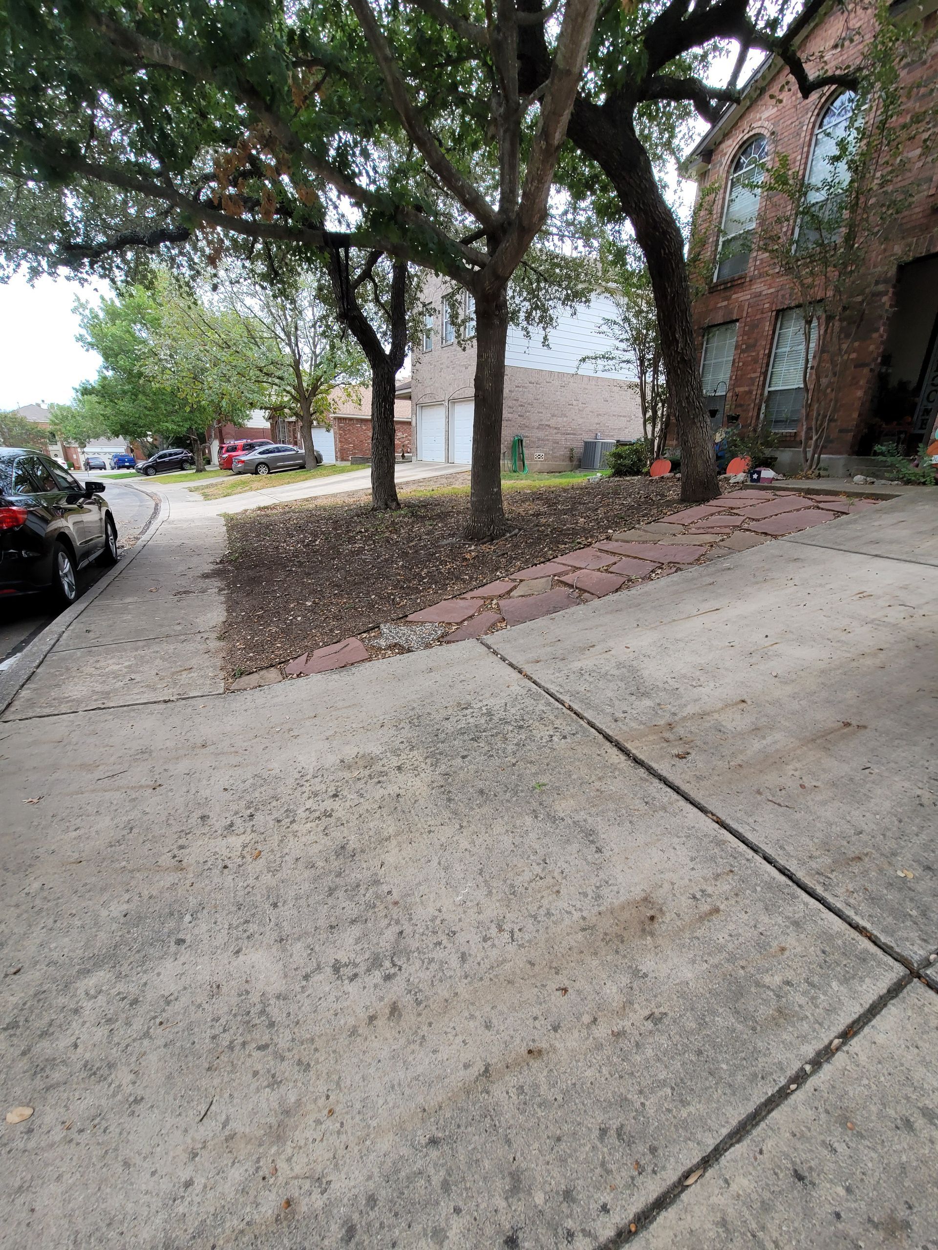 A stone walkway leading to a house in a residential neighborhood .