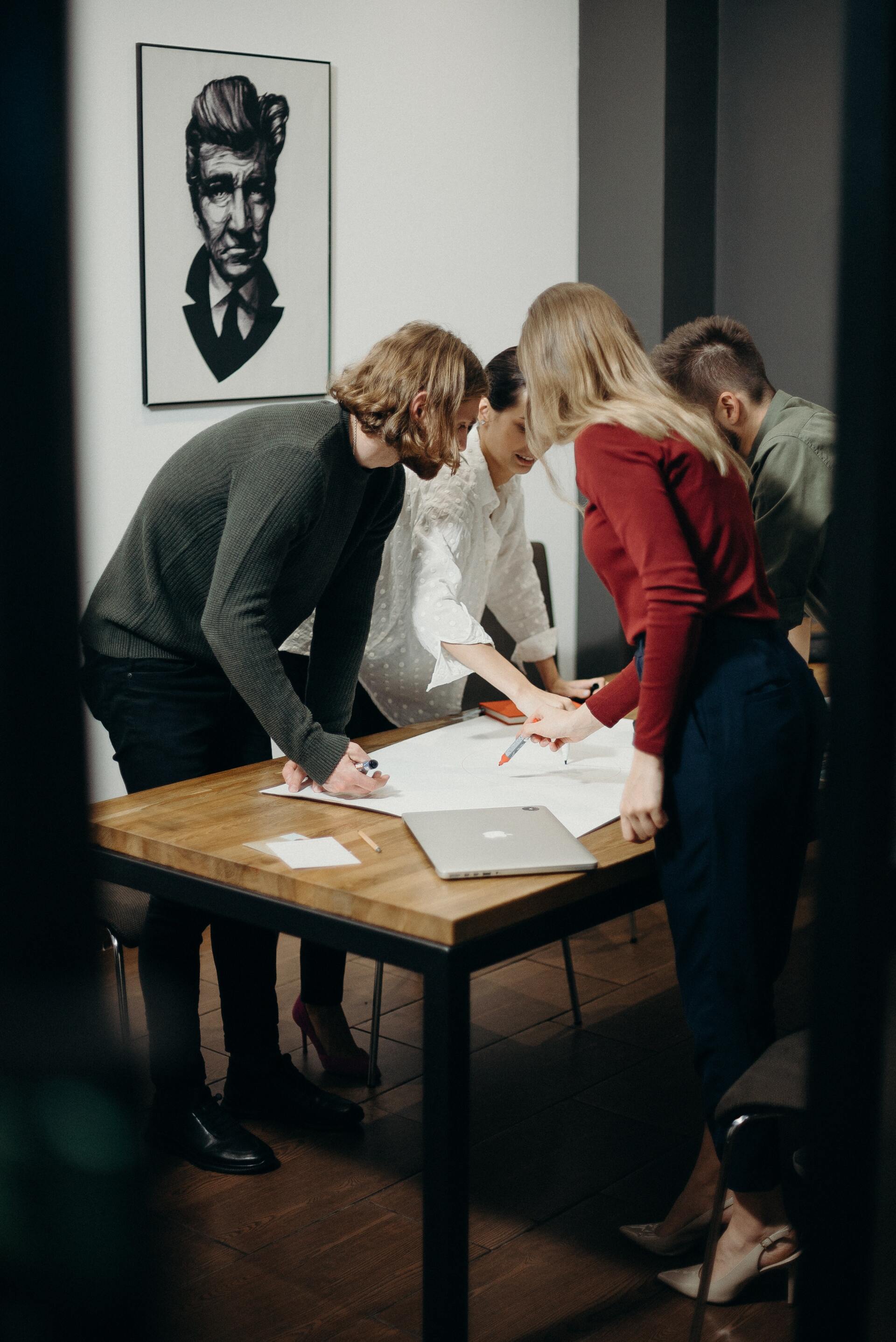 A group of people are sitting around a table looking at papers.