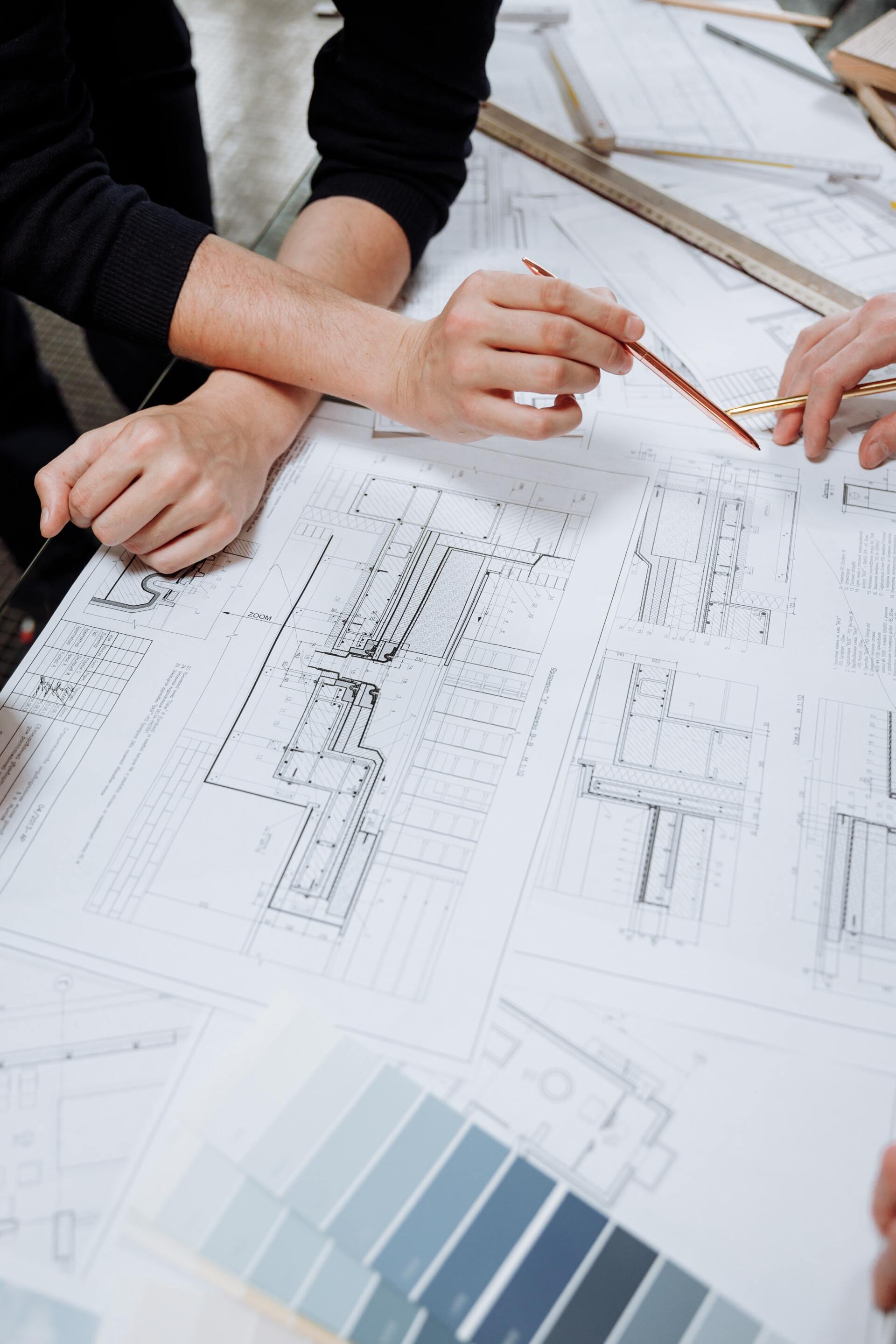 A group of people are sitting around a table looking at a blueprint.