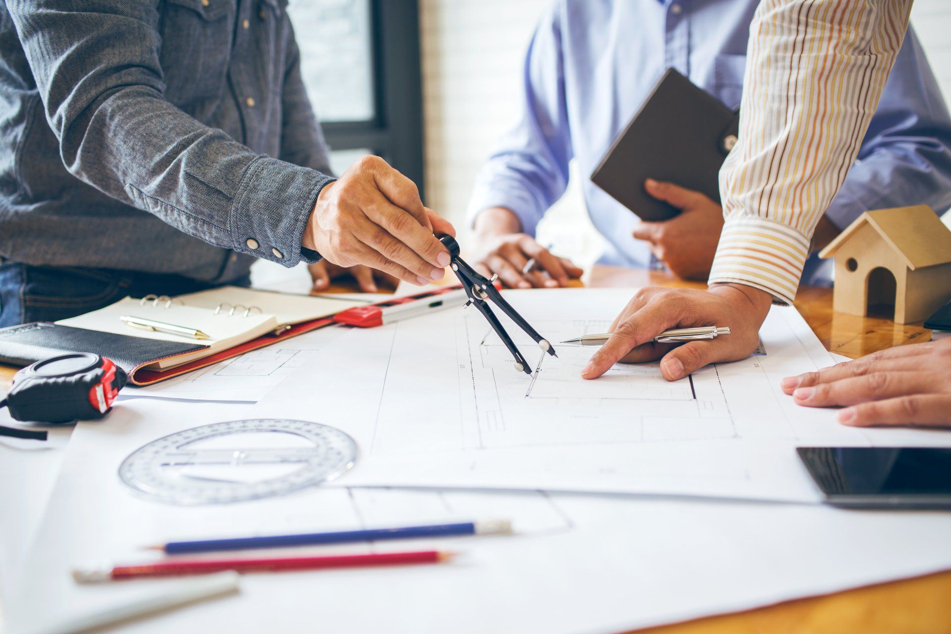 A group of people are sitting around a table looking at a blueprint.