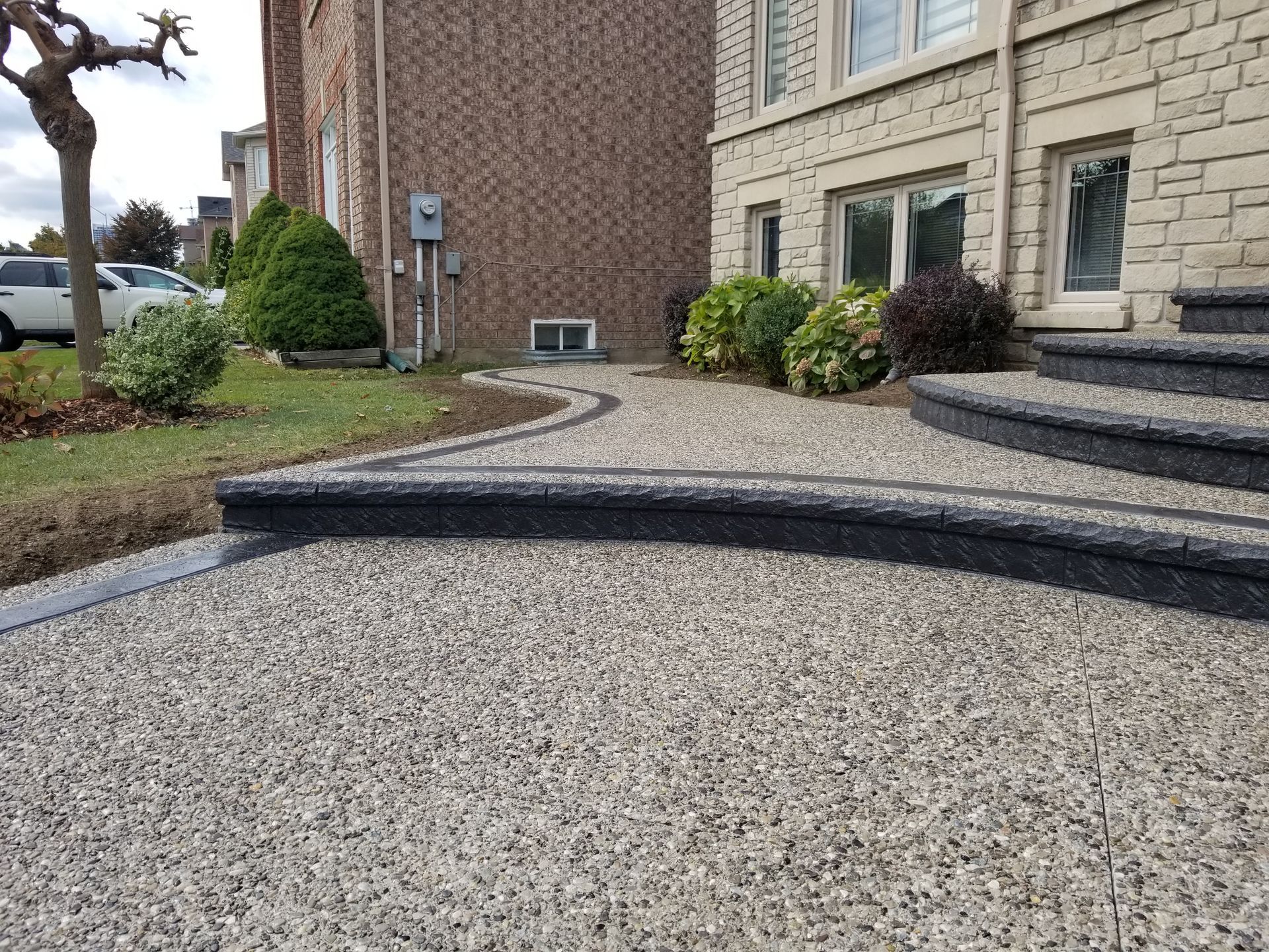A concrete walkway with stairs leading up to a house.